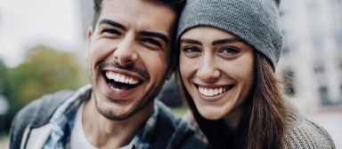 Man and woman with healthy smiles after periodontal disease treatment