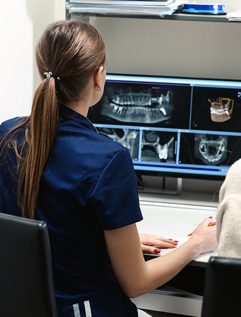 Dental team members looking at digital x-rays