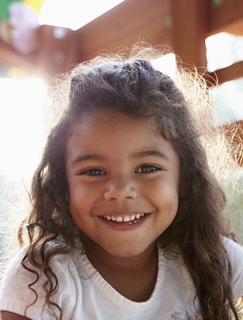 Little girl with healthy smile after dental sealants