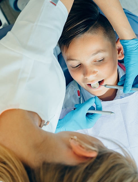 Dentist examining child's smile after silver diamine fluoride