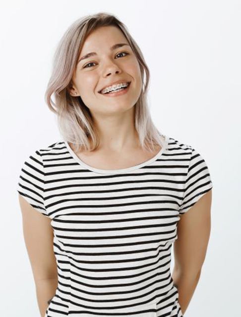 Teen girl with braces standing against white background