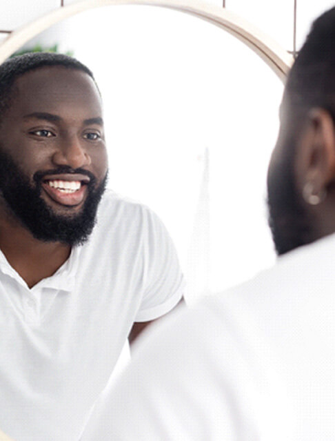 man looking at smile in reflection