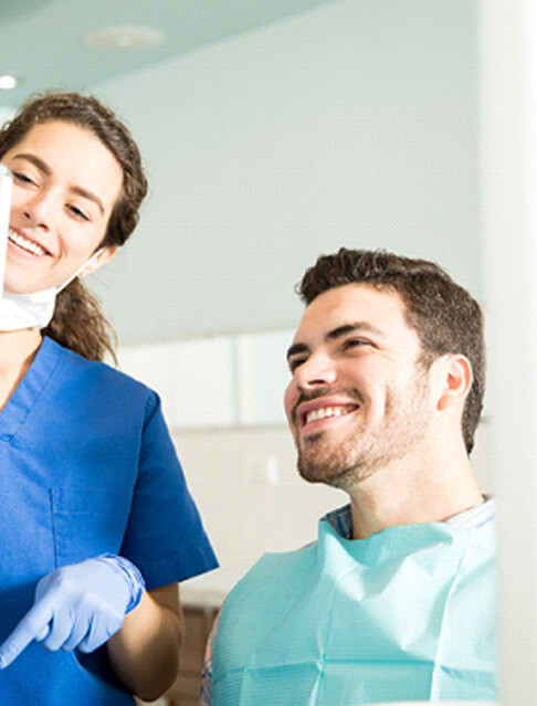 dentist showing patient image on tablet