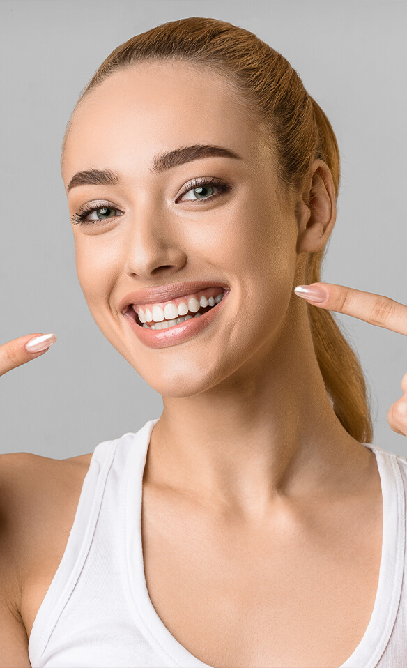 Woman pointing to her dental crown in Tucson