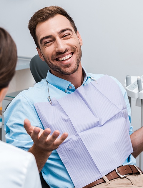 Man in dental chair smiling at dentist