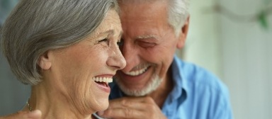 Man and woman smiling together after dental implant tooth replacement