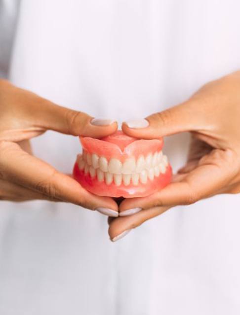 Lady presents viewer with dentures