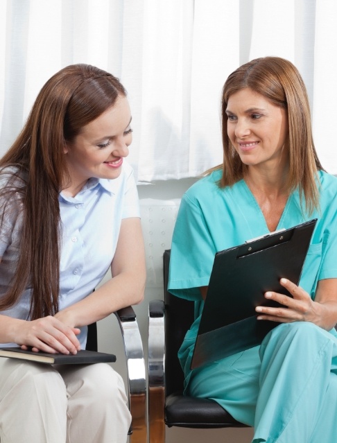 Dental team member and patient discussing the cost of dental emergencies