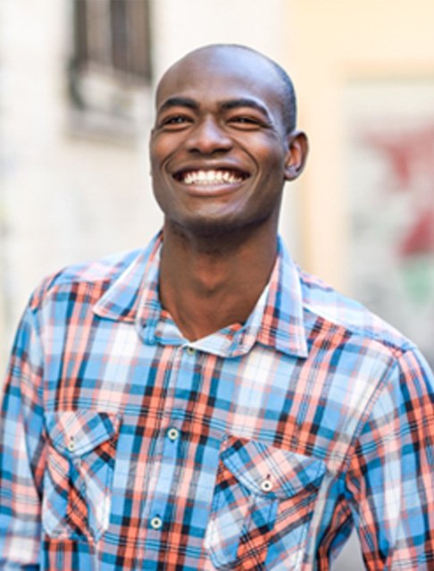 a person wearing a checked shirt and smiling