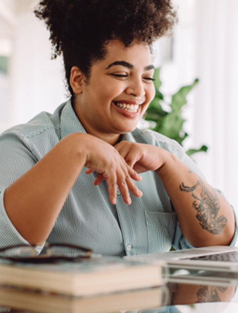 Woman smiling while working on laptop at home