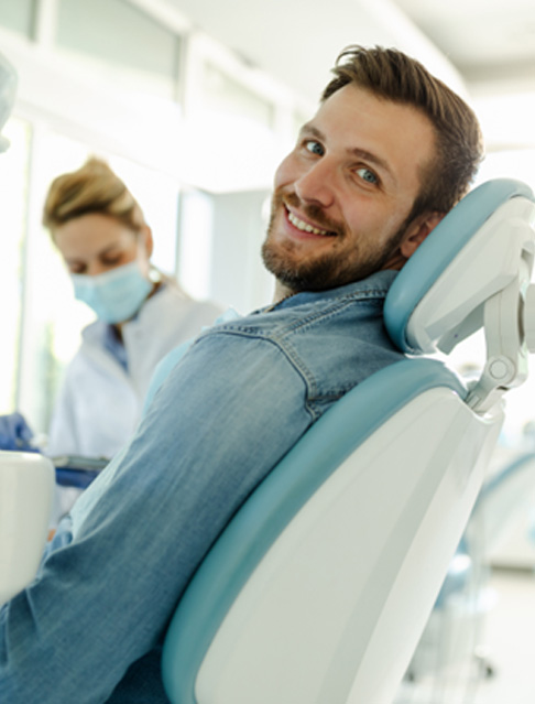 Man smiling while sitting in treatment chair