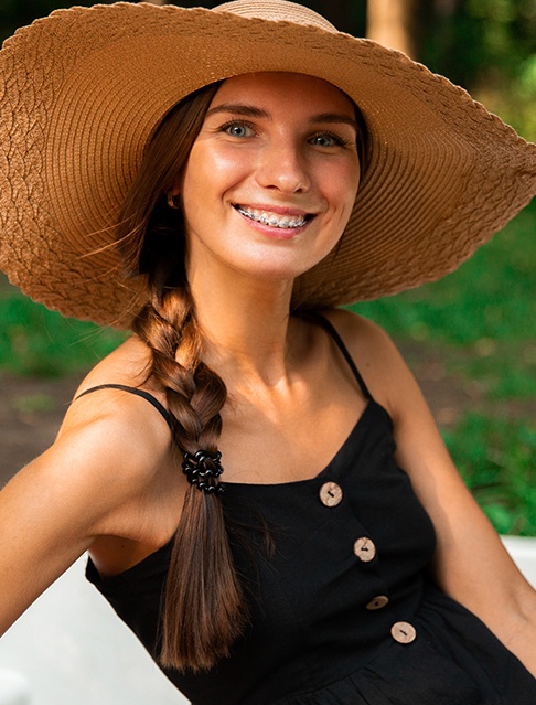 Woman with traditional orthodontics smiling