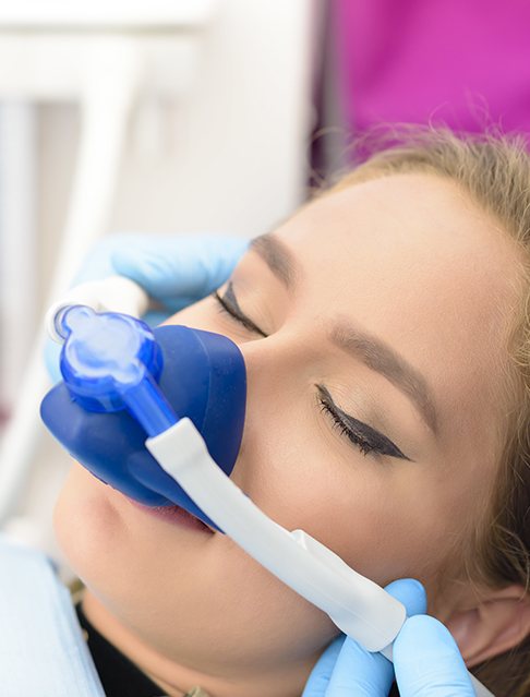 Relaxed woman with nitrous oxide dental sedation mask in place