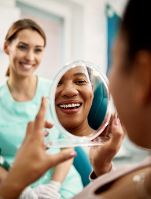Patient smiling at reflection in treatment chair