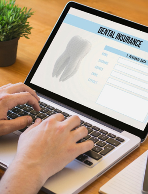 Patient filling out dental insurance form on computer