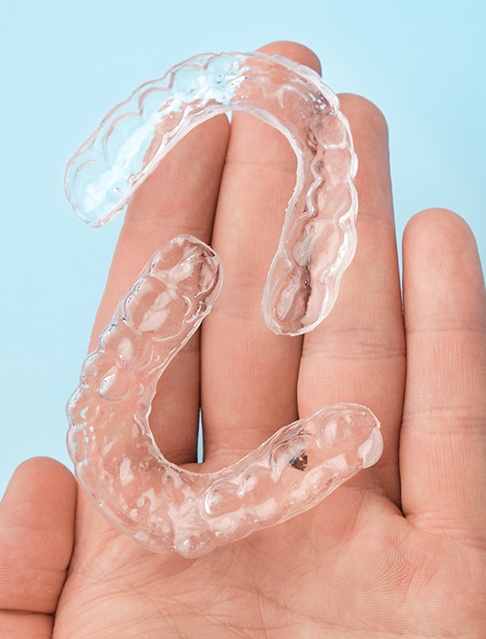 Two clear aligners resting on person’s hand