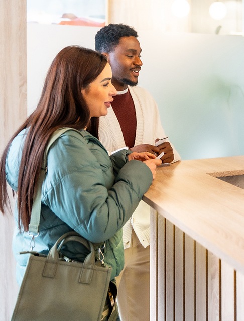 Dental team member talking to patients at front desk