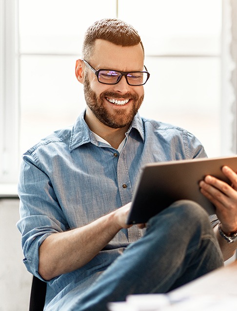 Smiling man emailing Doctor Fitzgerald from his tablet computer