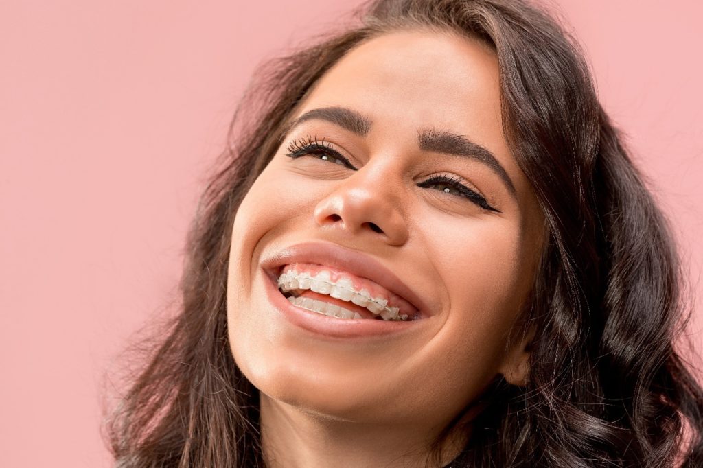 Woman with metal braces smiling.