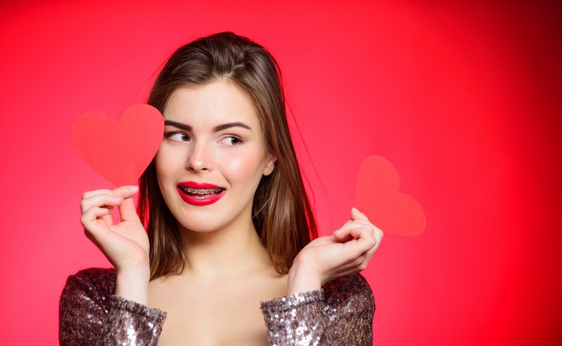 Woman with braces holding a valentines heart