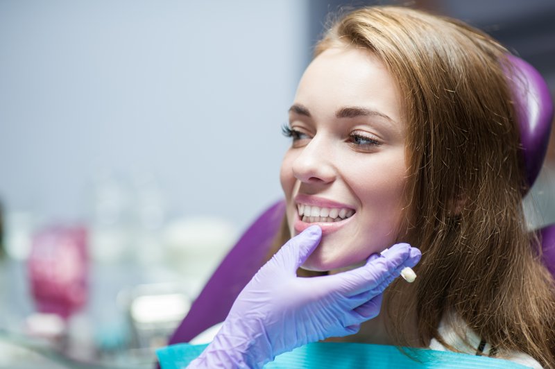 A dentist assessing a woman for dental crowns or fillings