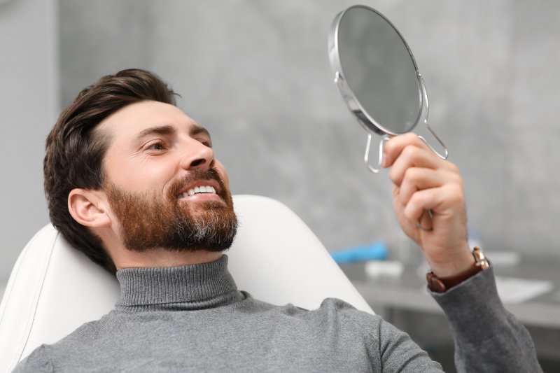 Man smiling after replacing his metal fillings